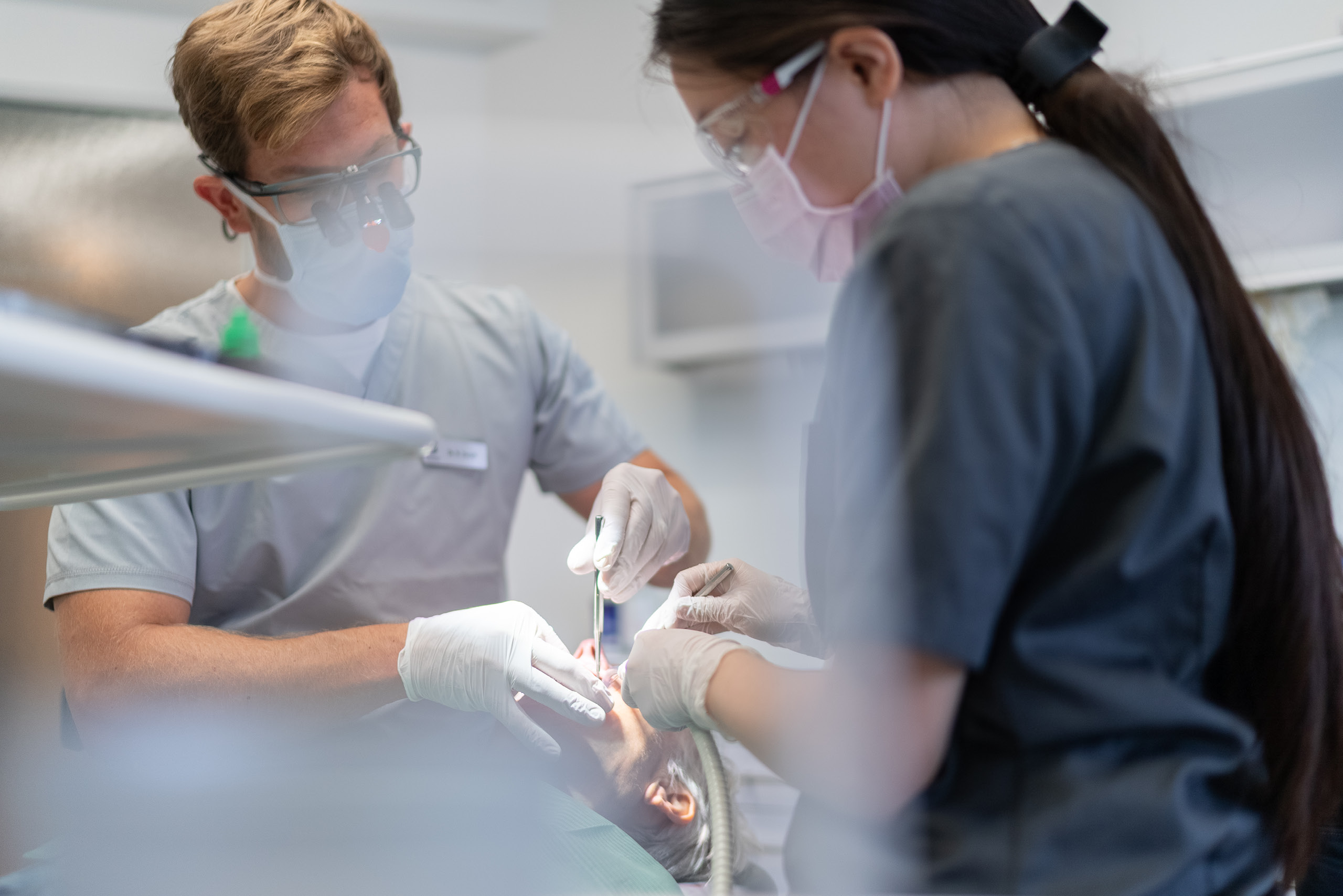 Zahnarzt und Assistenz bei der gemeinsamen Behandlung einer Patientin